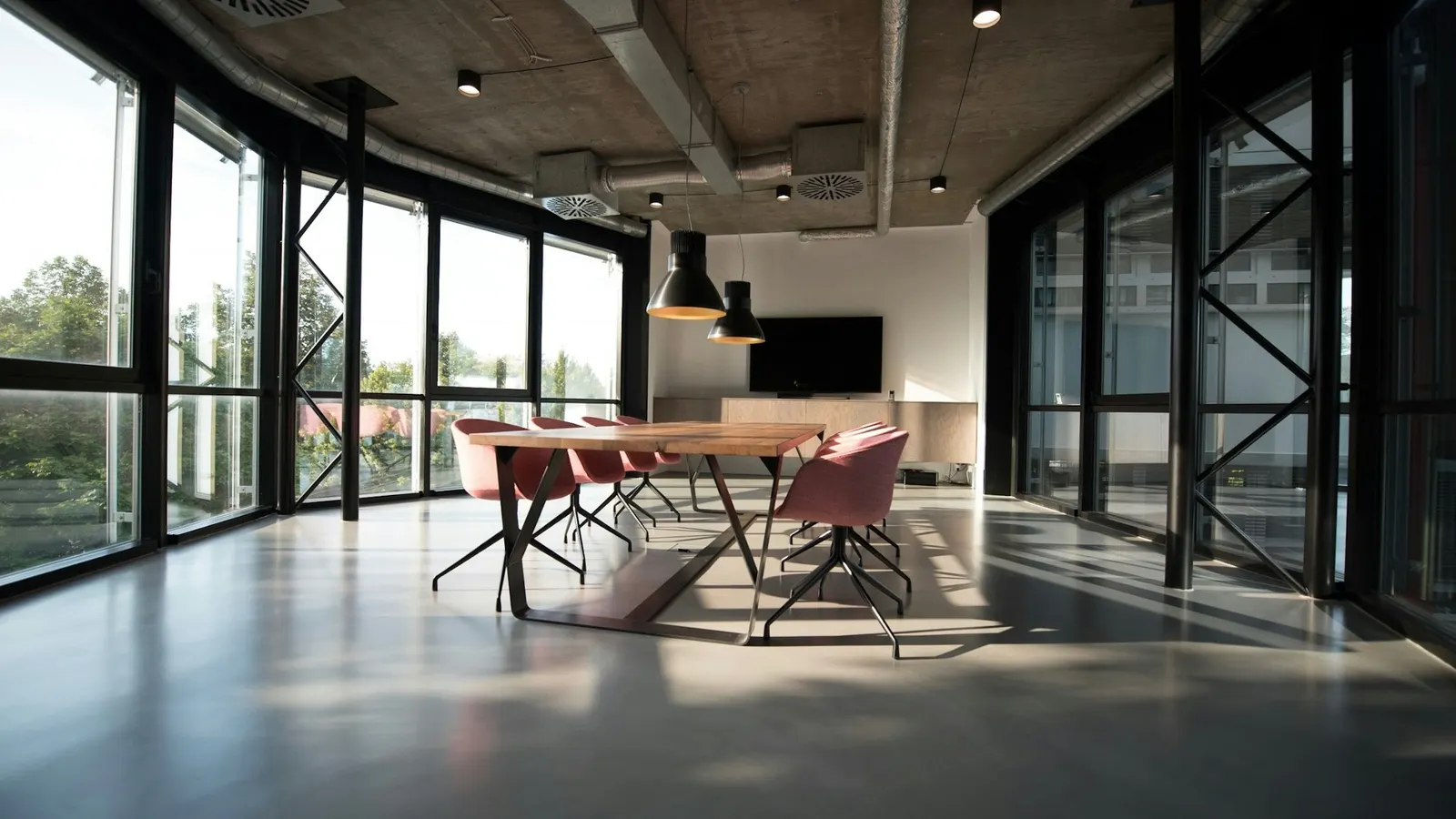 Modernes Büro mit Besprechungstisch und großen Fensterfronten